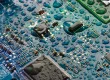 The circuit board of the motherboard is covered with drops of water in blue-green tones.