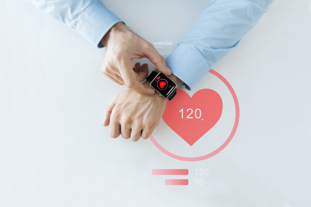 Man monitoring heart rate with a smartwatch, showcasing wearable medical devices for health tracking.